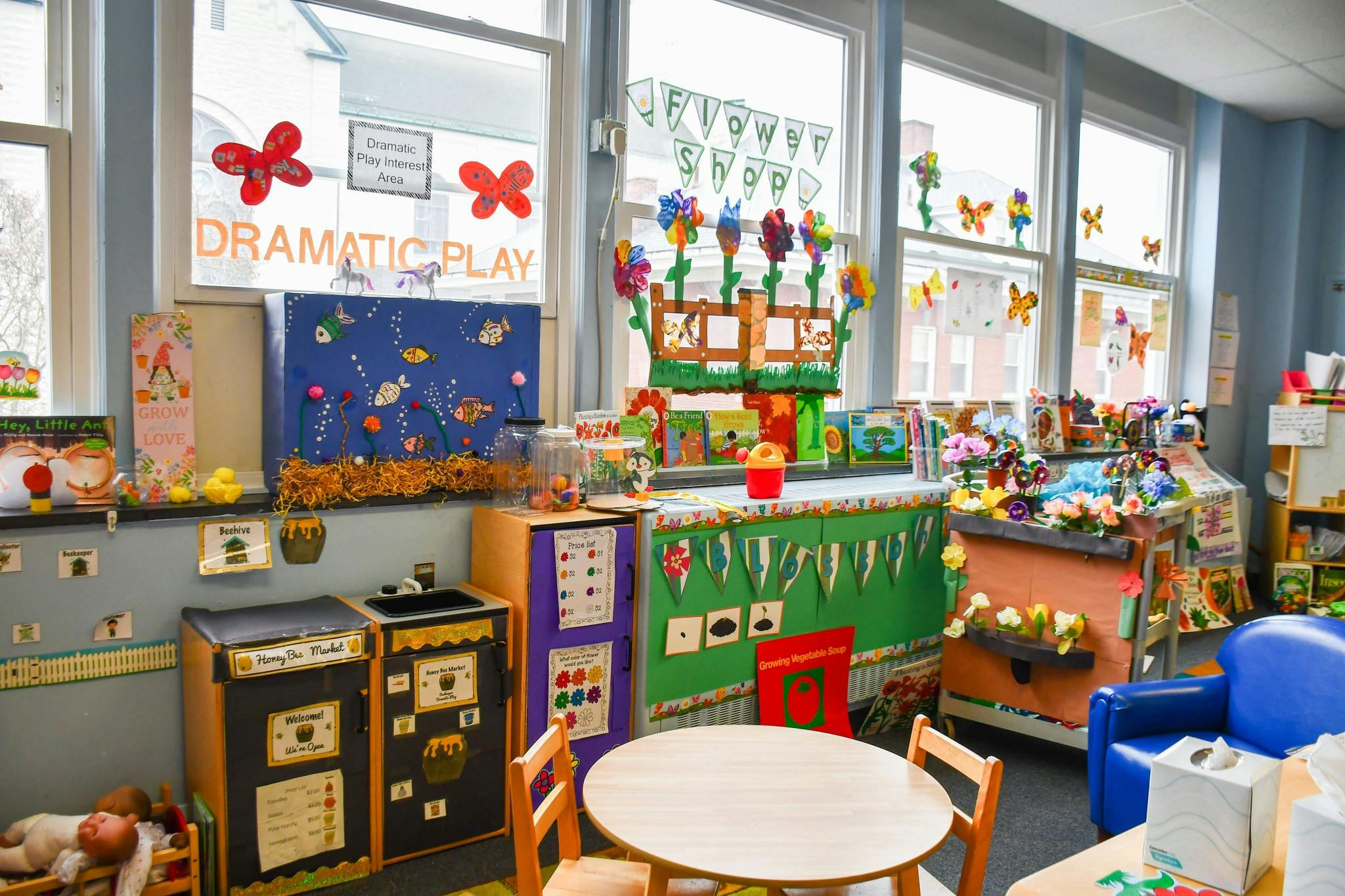 Classroom with windows, tables, chairs, and decorations