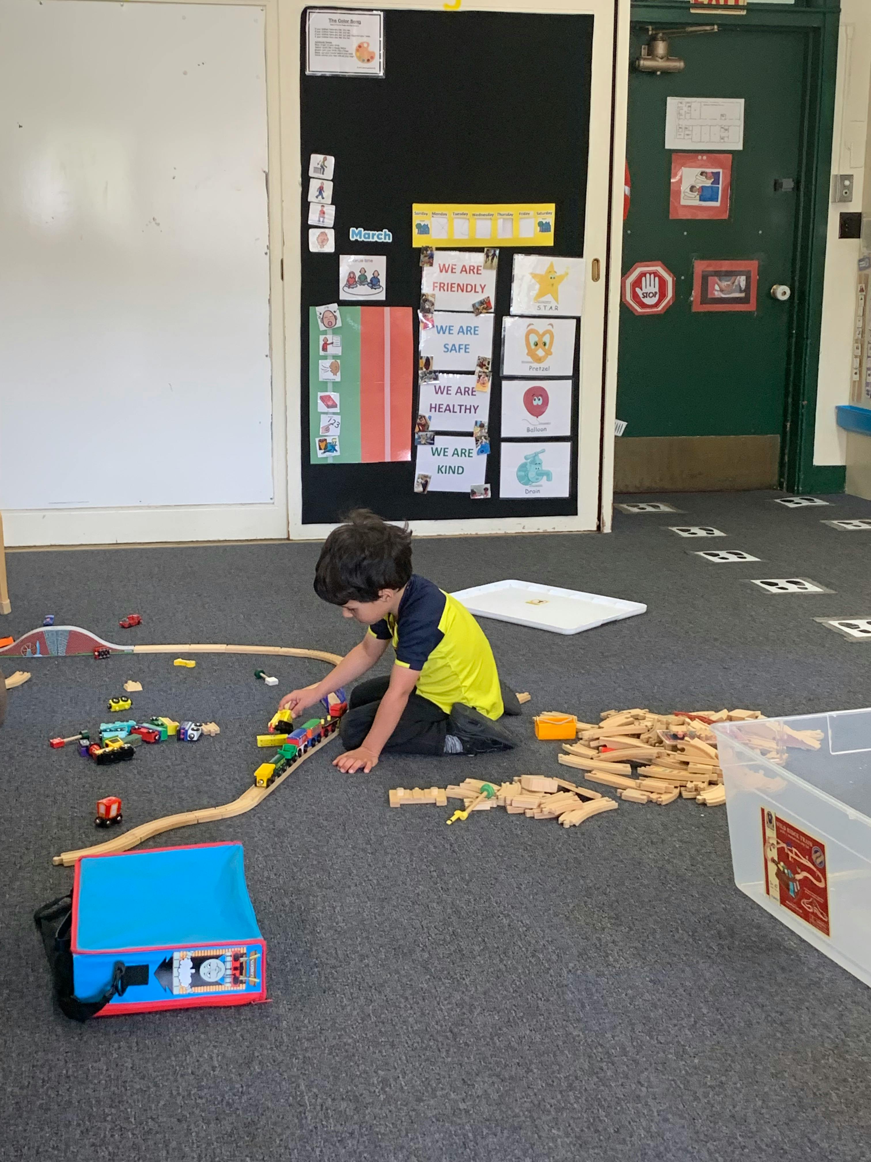 Child playing with a toy train on the floor