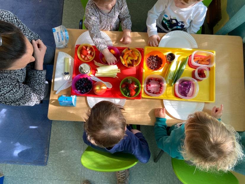 Adult and children at a table with trays of food