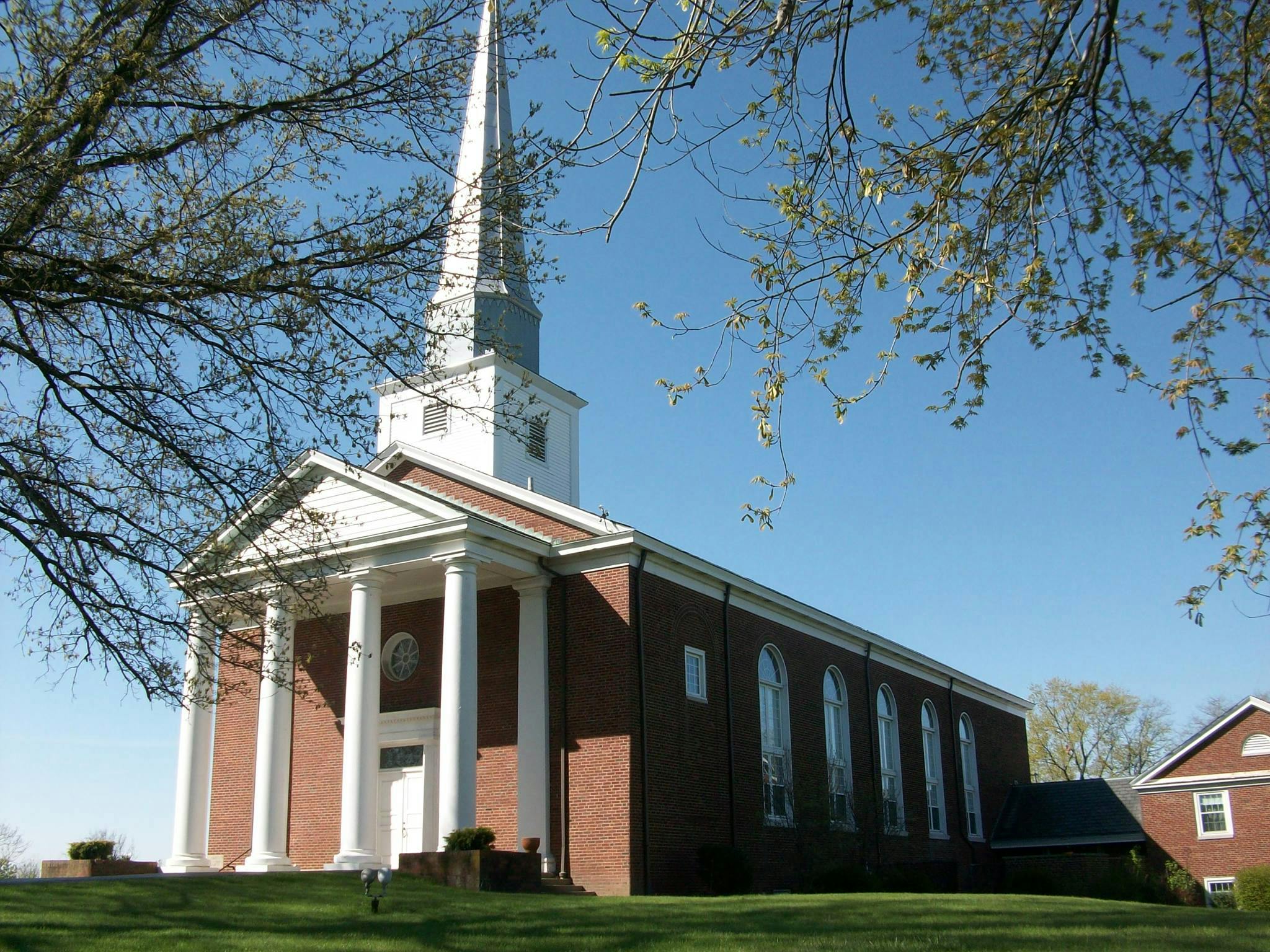 Brick church with a white steeple and columns