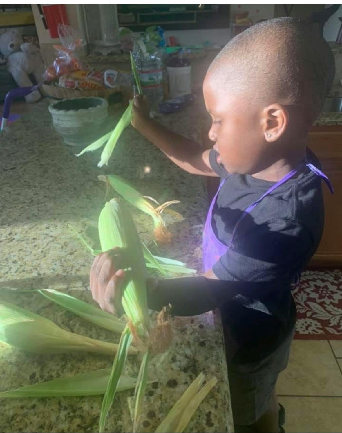 Child shucking corn