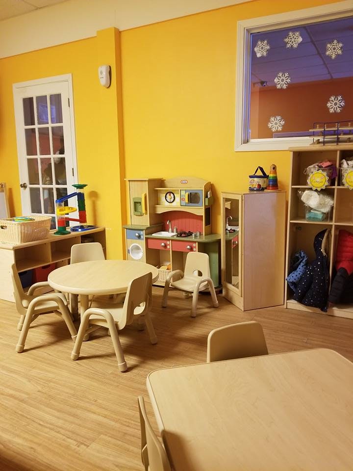 Children's play area with small tables, chairs, and toy kitchen set