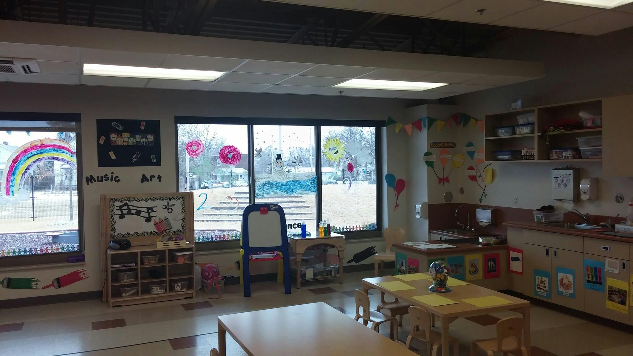 Empty classroom with tables, chairs, and windows