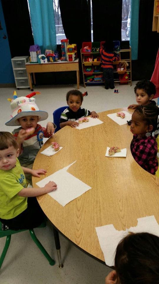Children sitting at a table with donuts