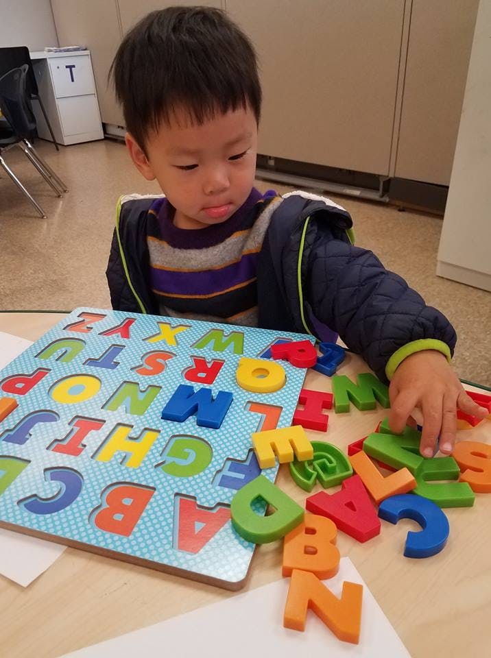 Child playing with an alphabet puzzle