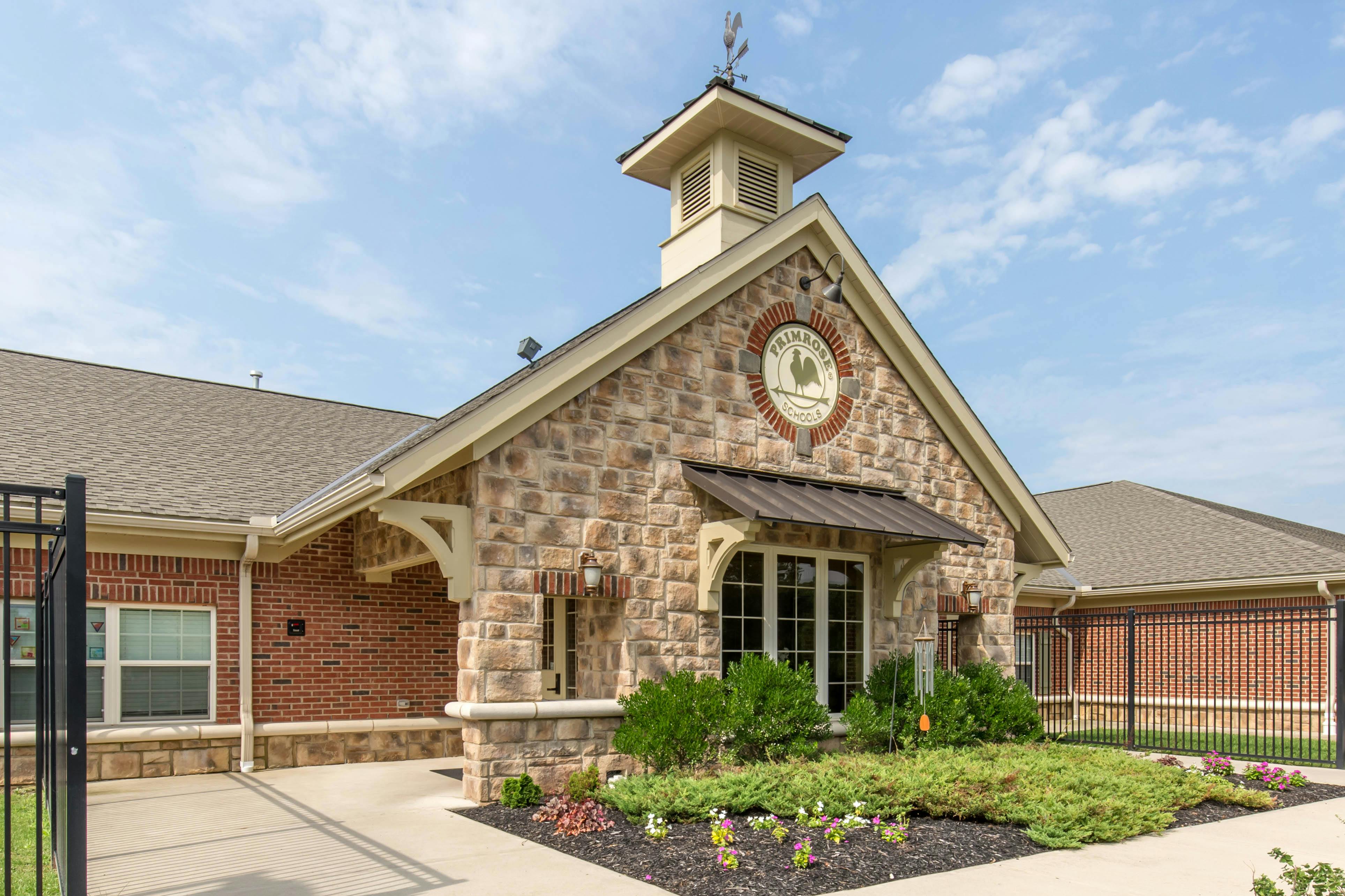 A stone and brick building with a sign that reads "Primrose Schools"