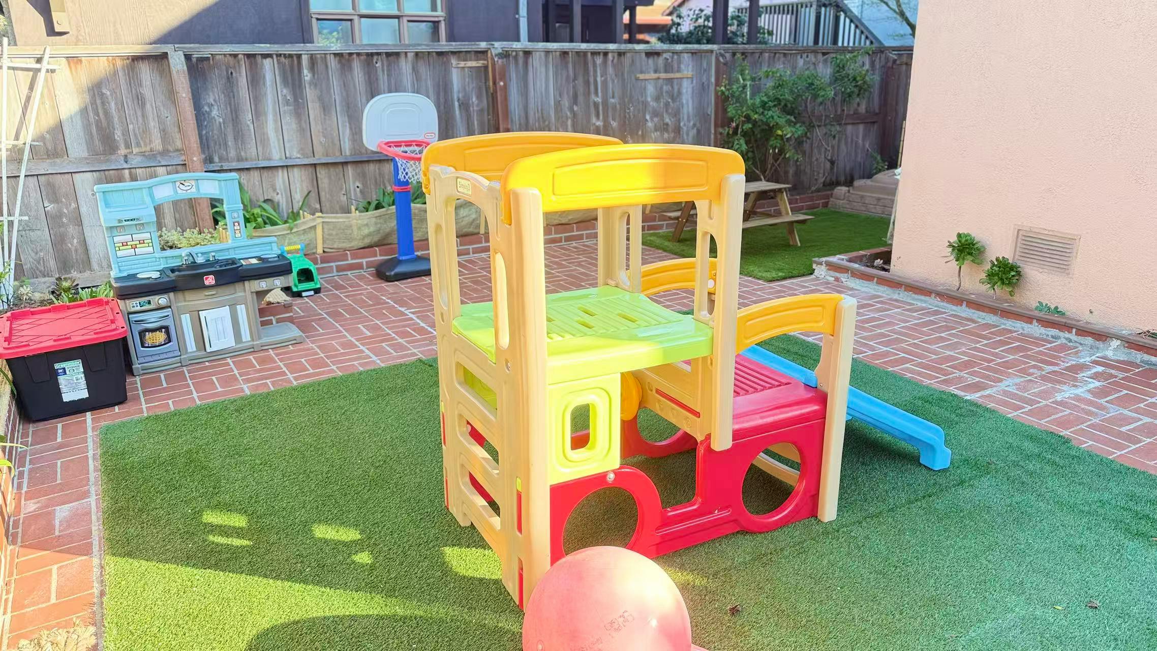 Colorful plastic play structure with a slide on artificial turf