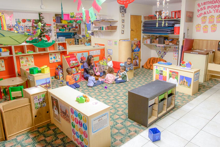 Adult and children sitting on the floor in a classroom