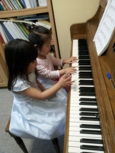 Two children playing piano