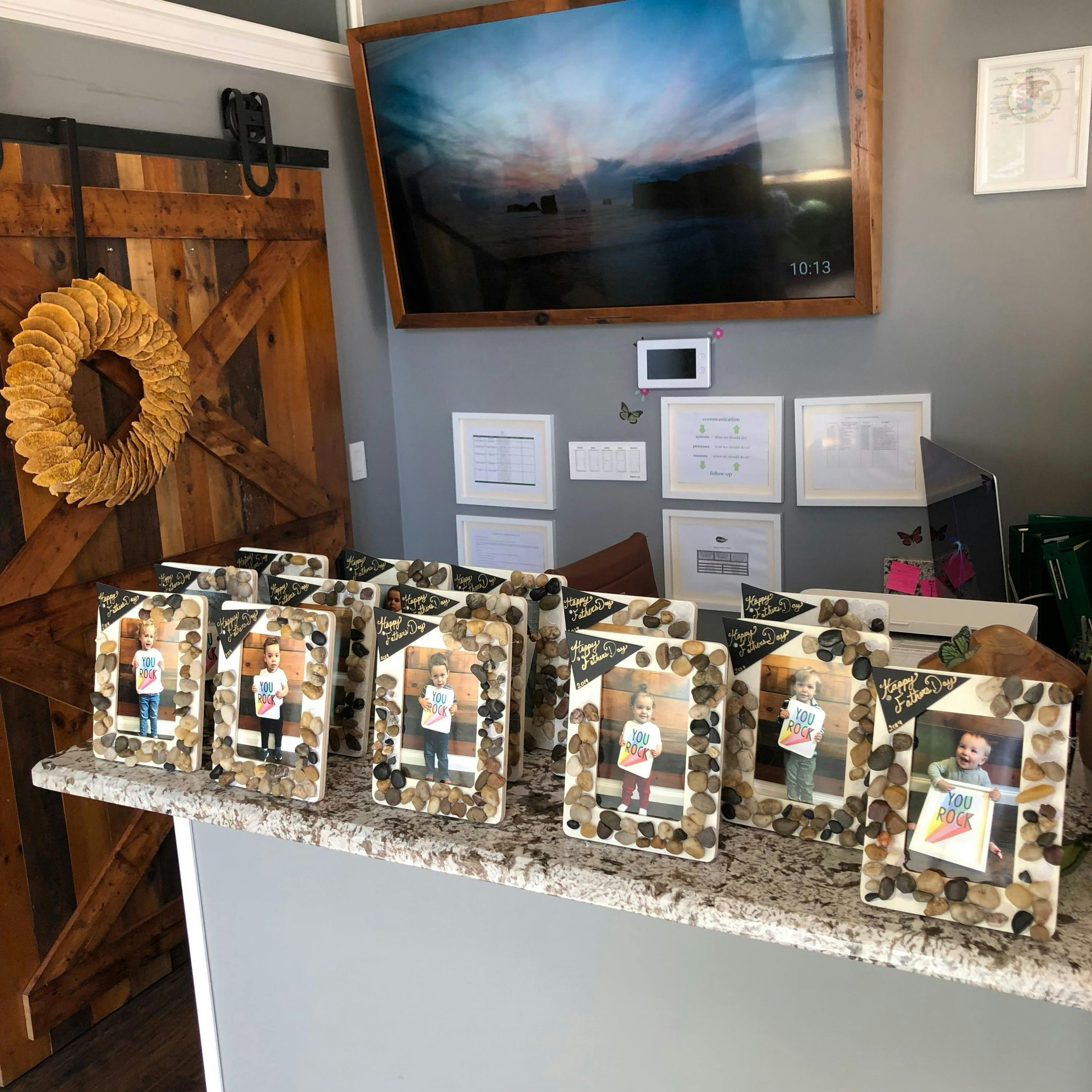 Multiple framed photos of children on a counter