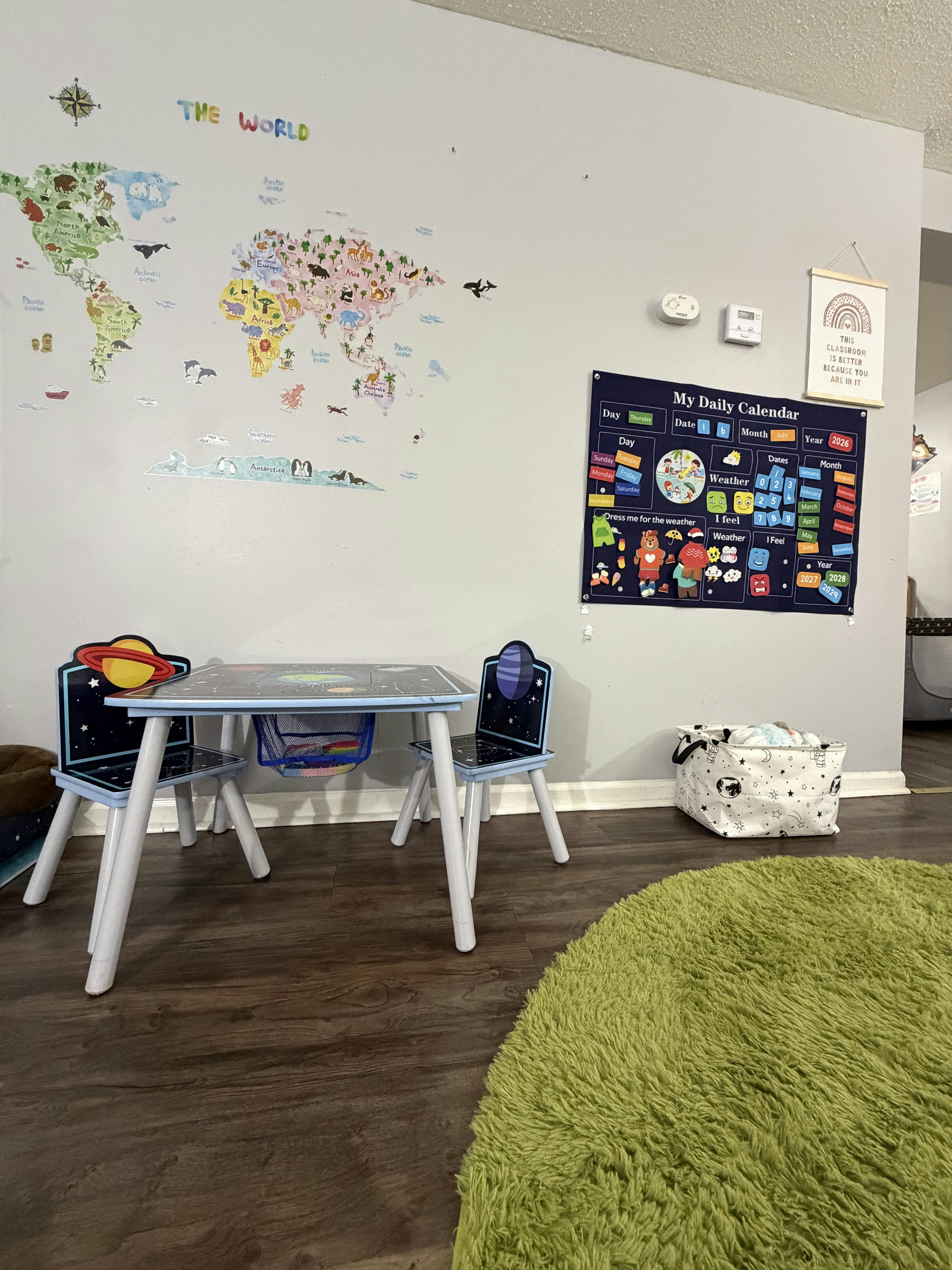 Children table and chairs in front of a wall with a world map and calendar