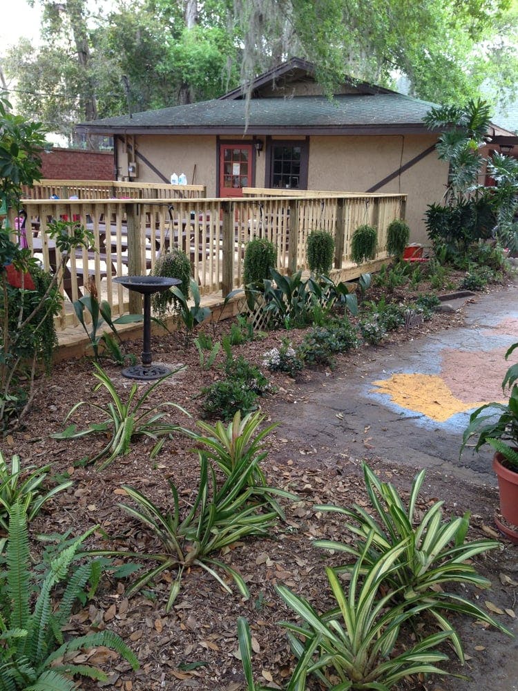 Building with a wooden deck and garden in front