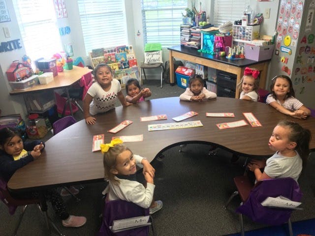 Group of children sitting around a table in a classroom