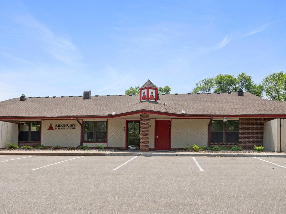 Building with a KinderCare Learning Center sign, parking spaces in foreground