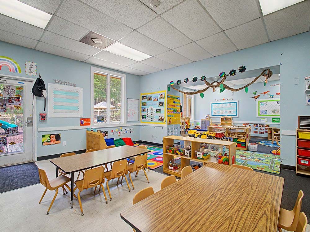 Classroom with tables, chairs, toys, and decorated walls