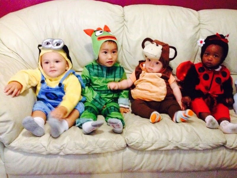 Four children in costumes sitting on a couch