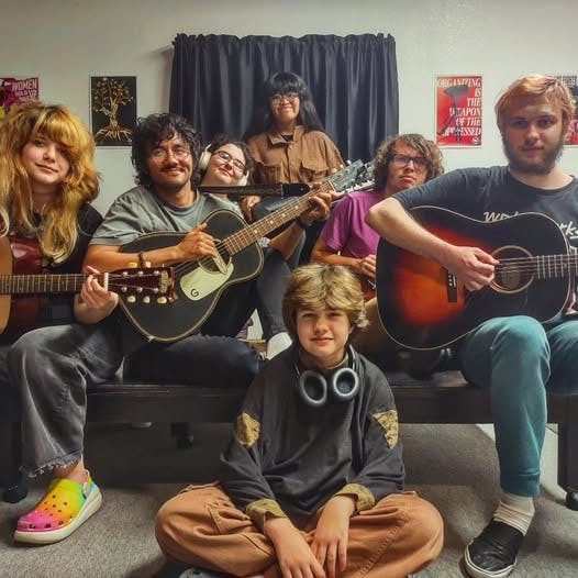 Group of people, mostly teens and young adults, with guitars