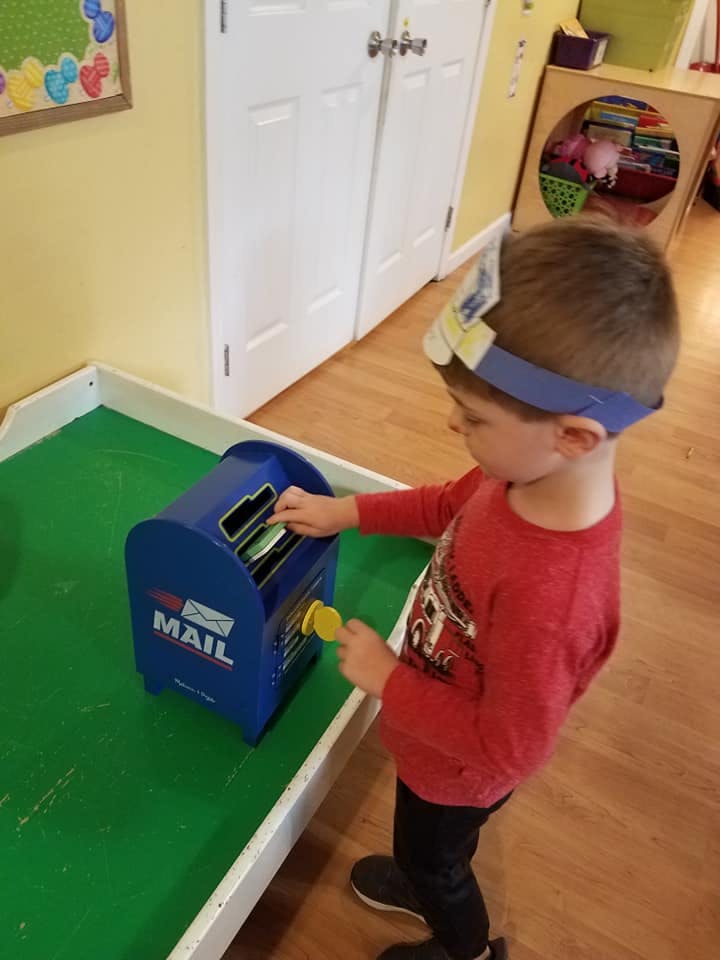Child playing with a toy mailbox