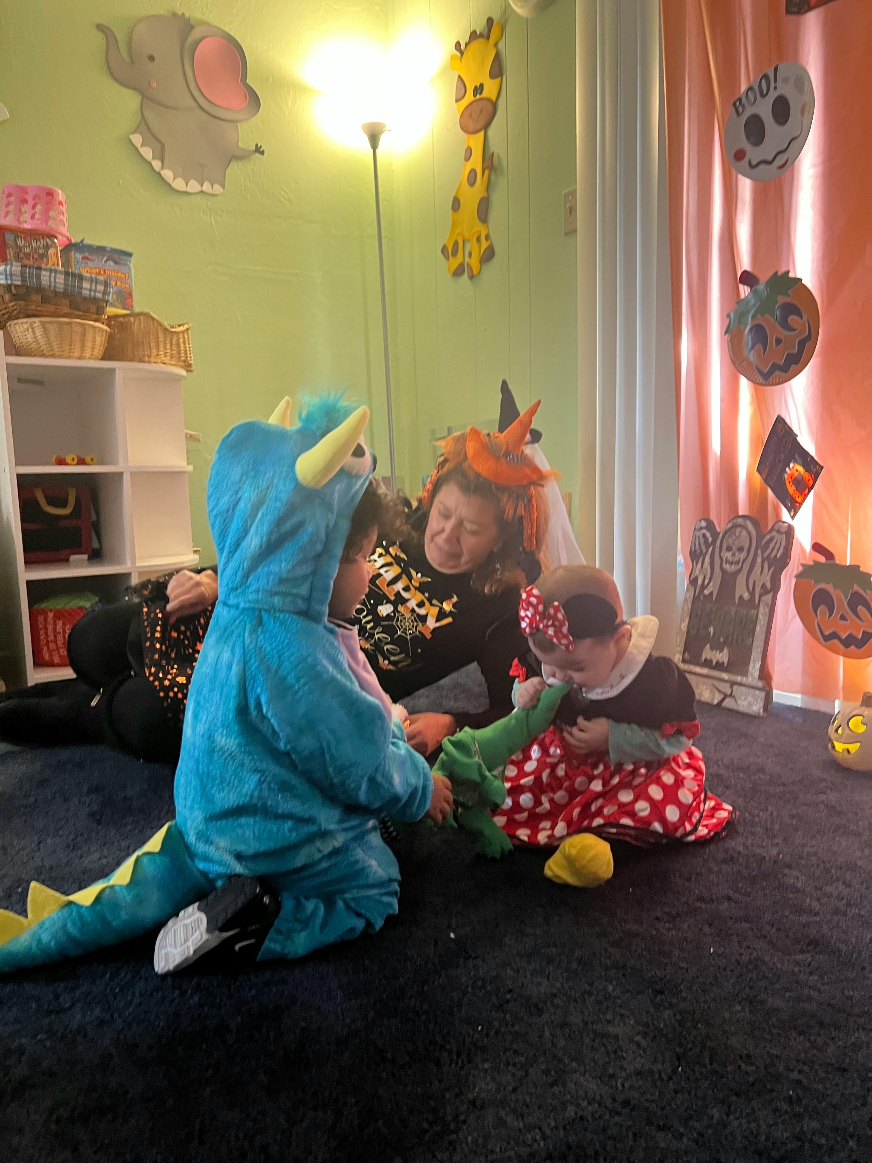 Person and two children in costumes playing with a toy
