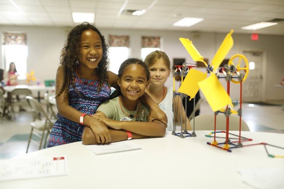 Three children with a model windmill on a table