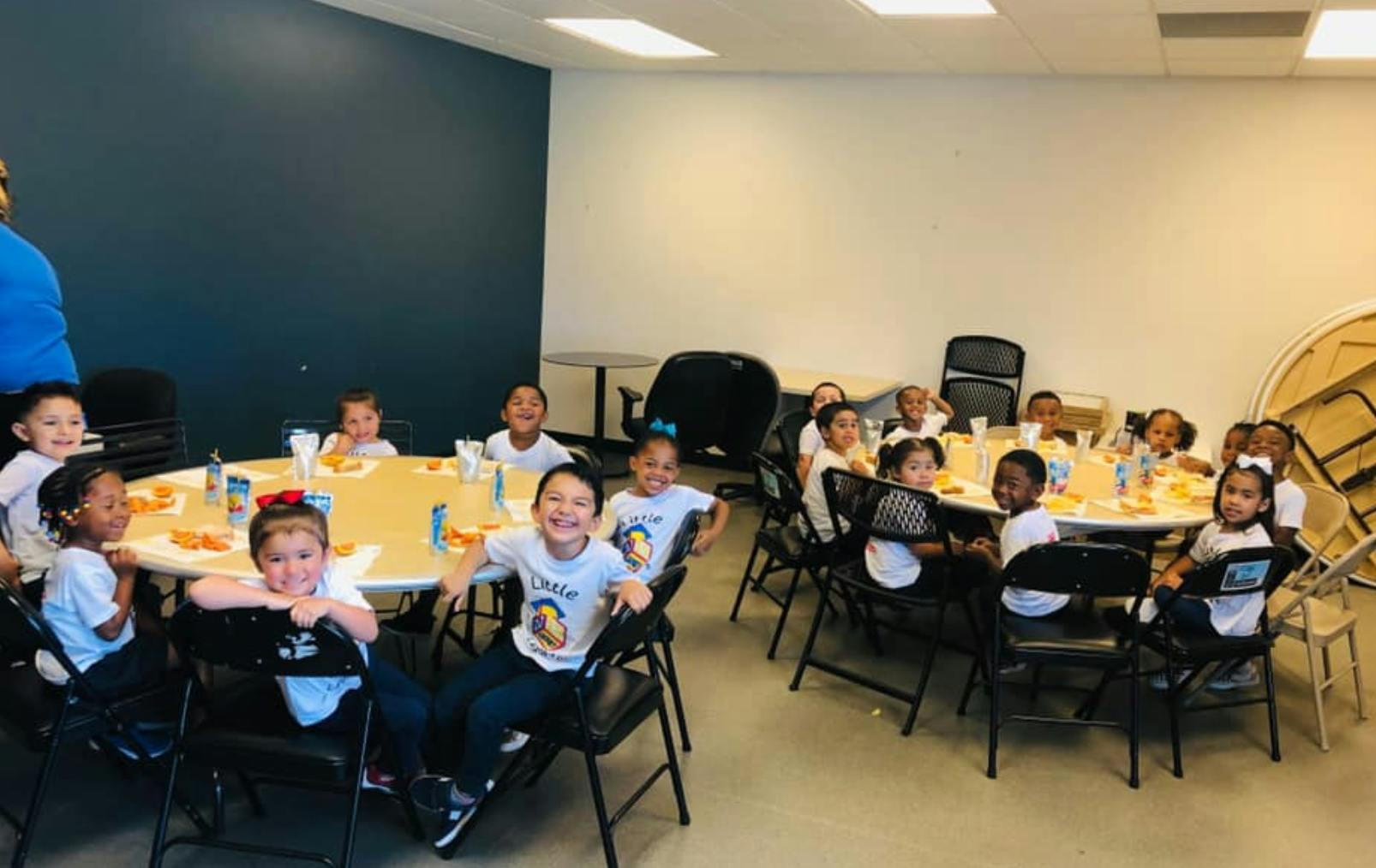 Children sitting at tables in a room
