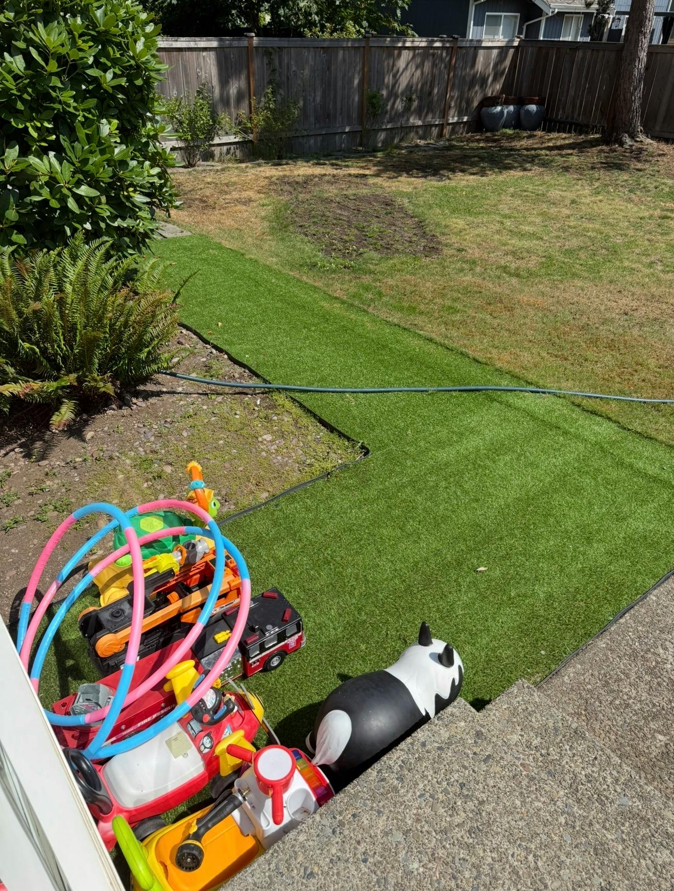 Collection of children's toys and hula hoops on an artificial grass lawn