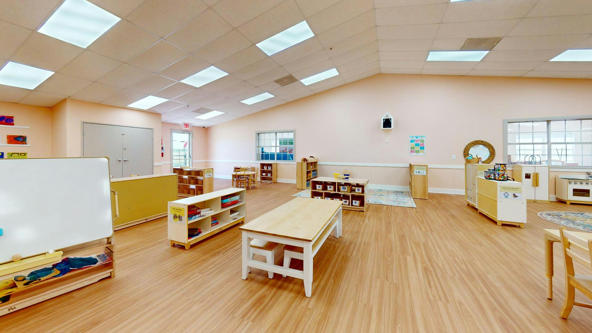 Empty classroom with tables, shelves, and a whiteboard
