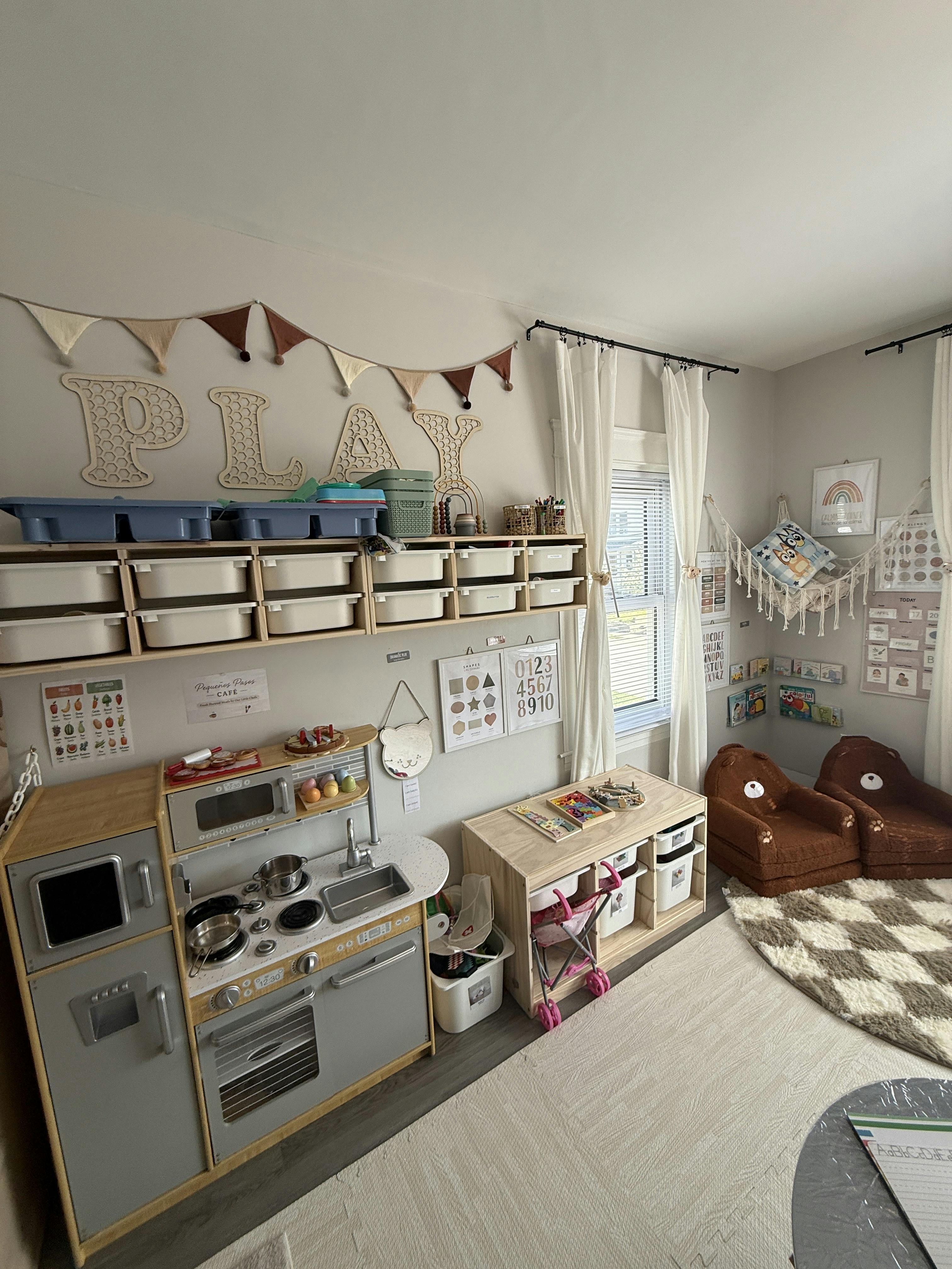 Playroom with a toy kitchen, storage shelves, and small bear-shaped chairs