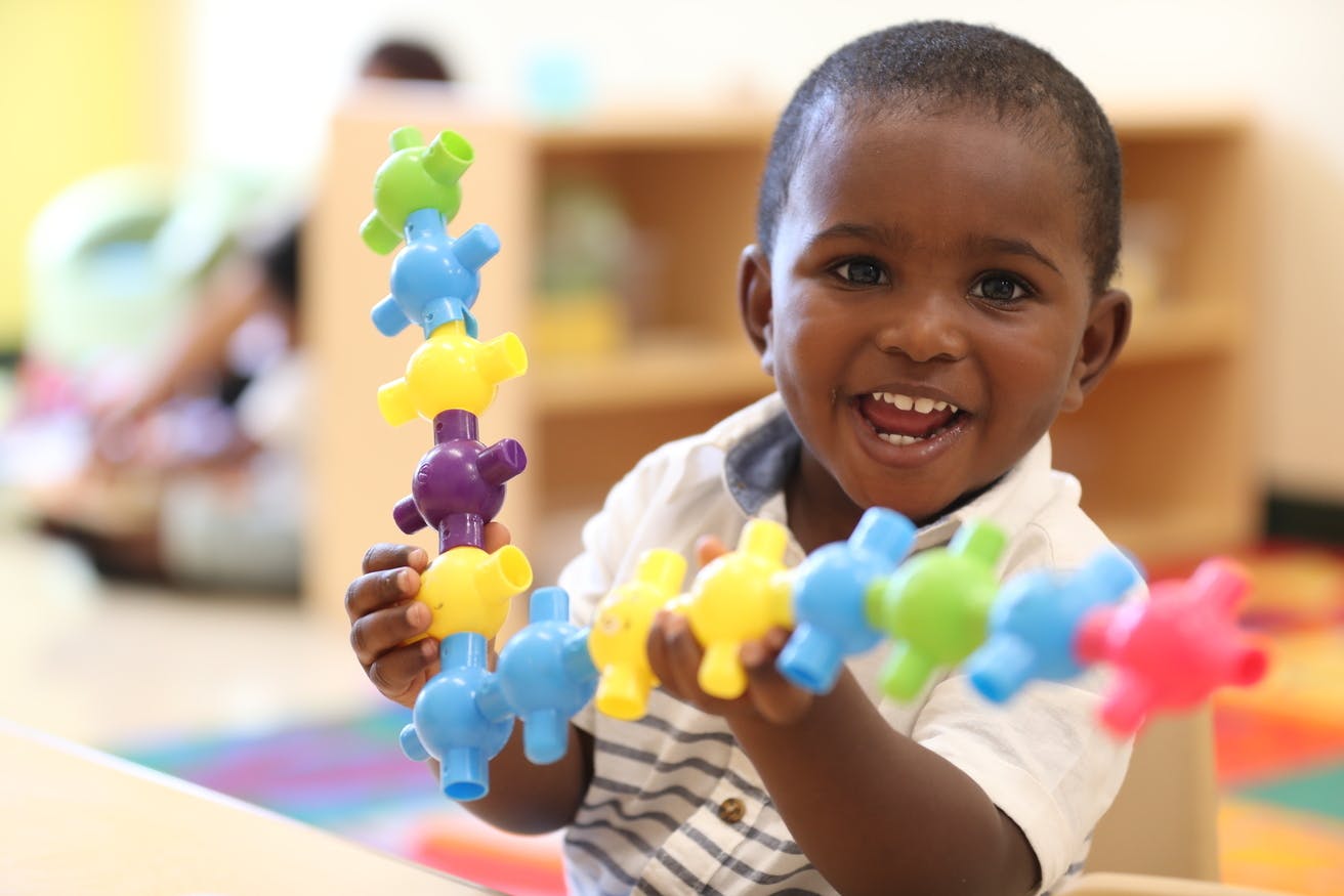 Child holding colorful interlocking toys