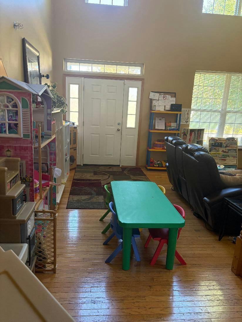 Small table and chairs in a room with a dollhouse and toy storage