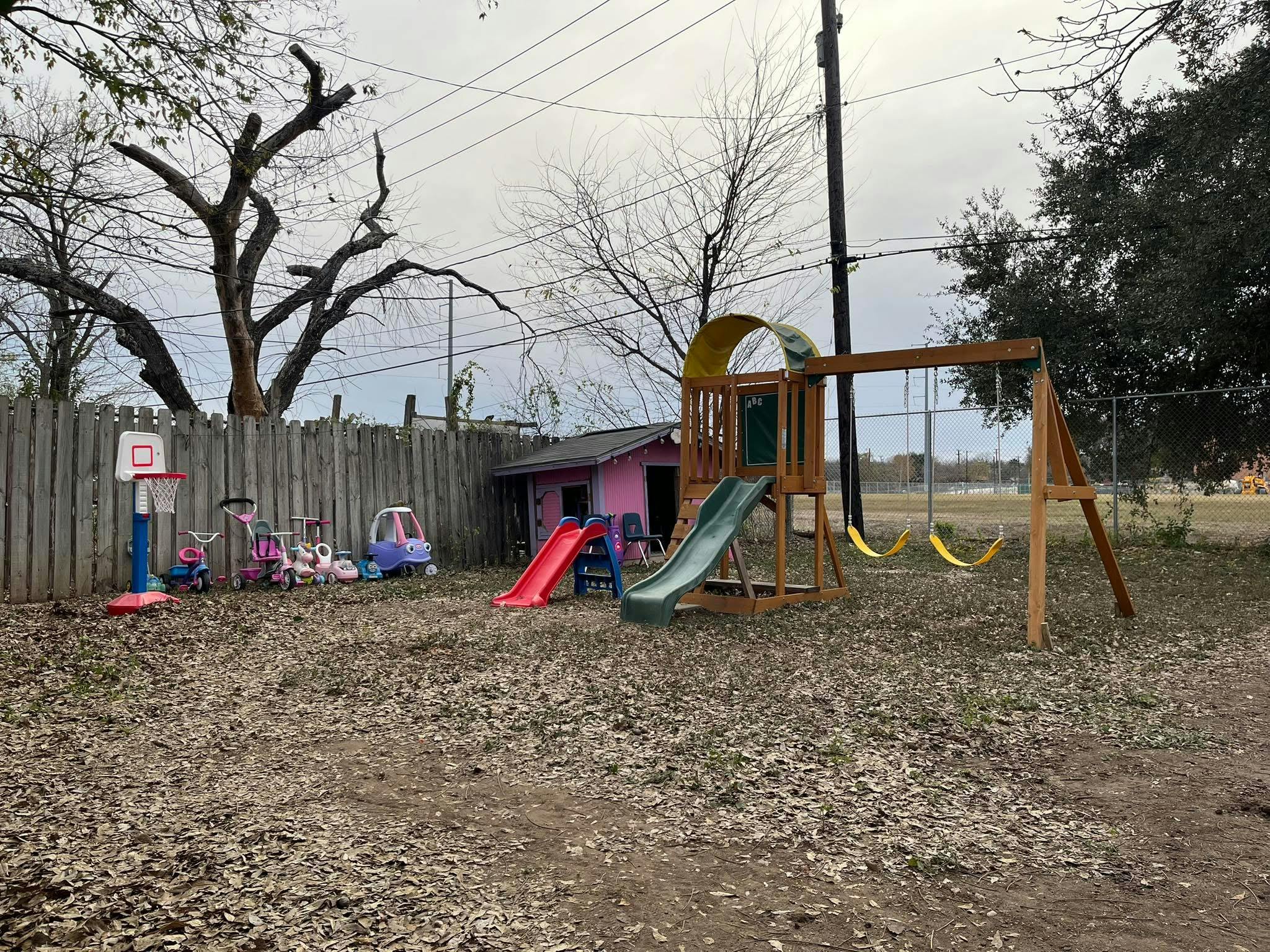 children's playground with slides, swings, toy cars, and basketball hoop