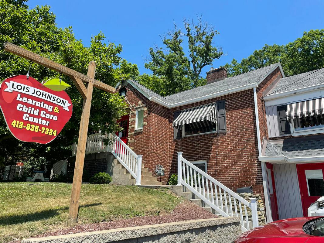 Sign for Lois Johnson Learning and Child Care Center outside a brick building