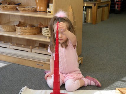Child playing with a red stacking toy