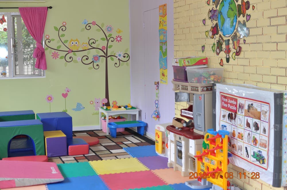 Playroom with colorful floor mats, soft play blocks, and wall decorations