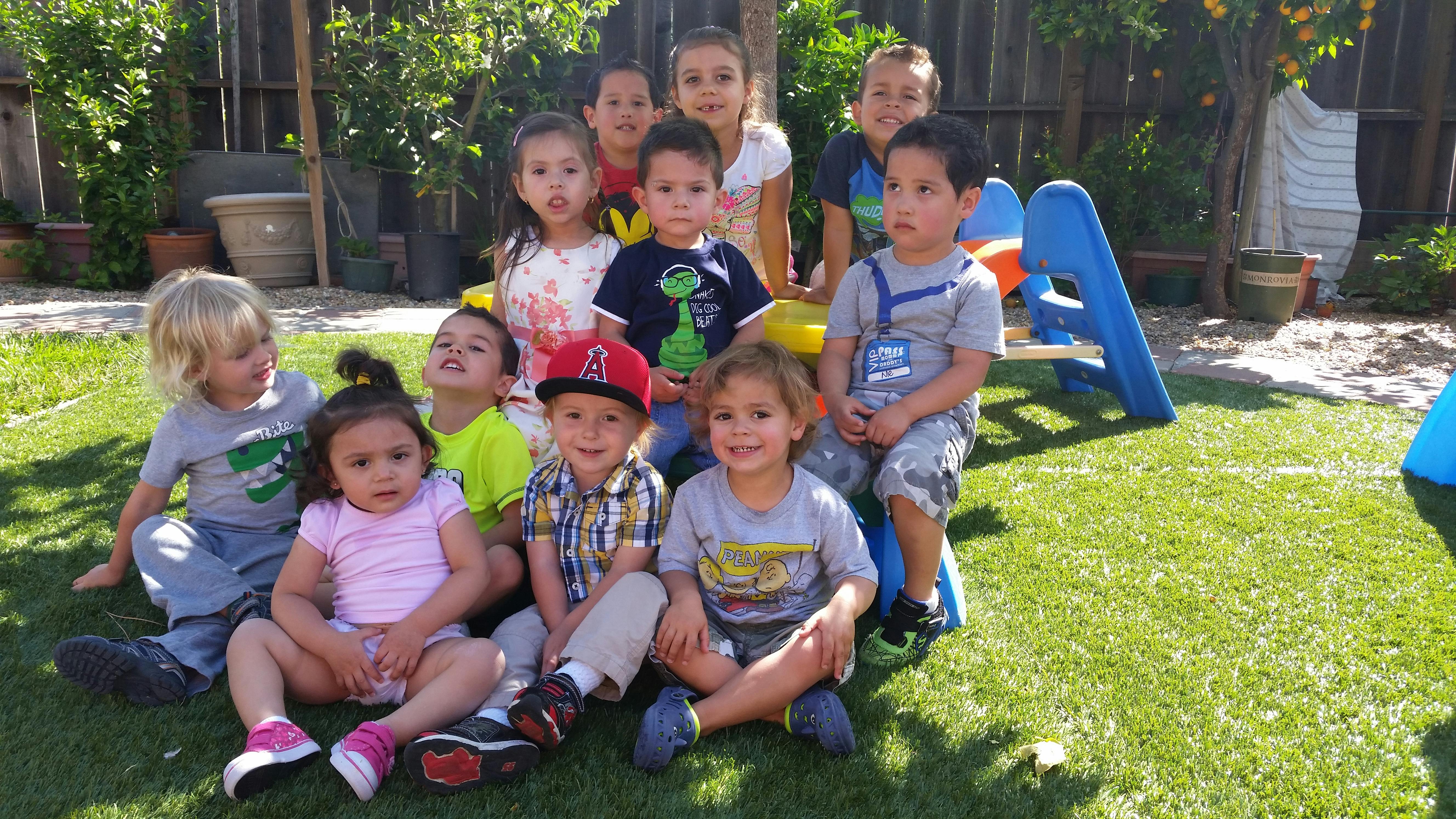 Group of children sitting on grass outdoors