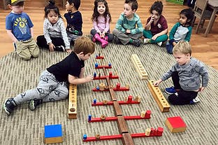 Children playing with wooden blocks on a rug