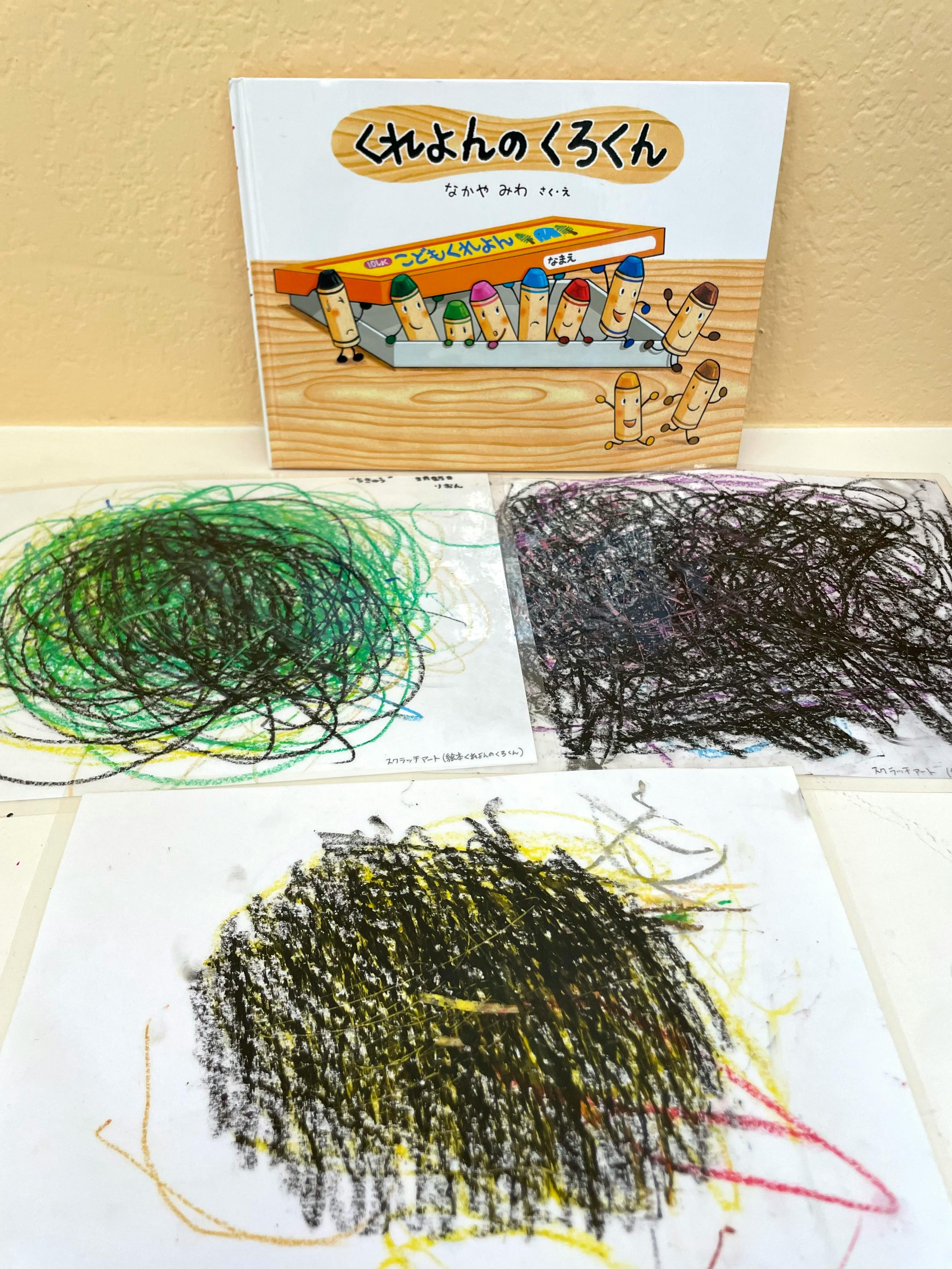 Children's book with crayon characters and three crayon scribbles on paper