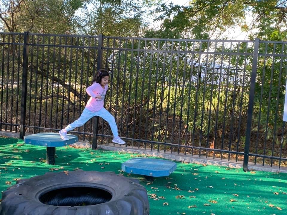Child jumping between platforms on a playground