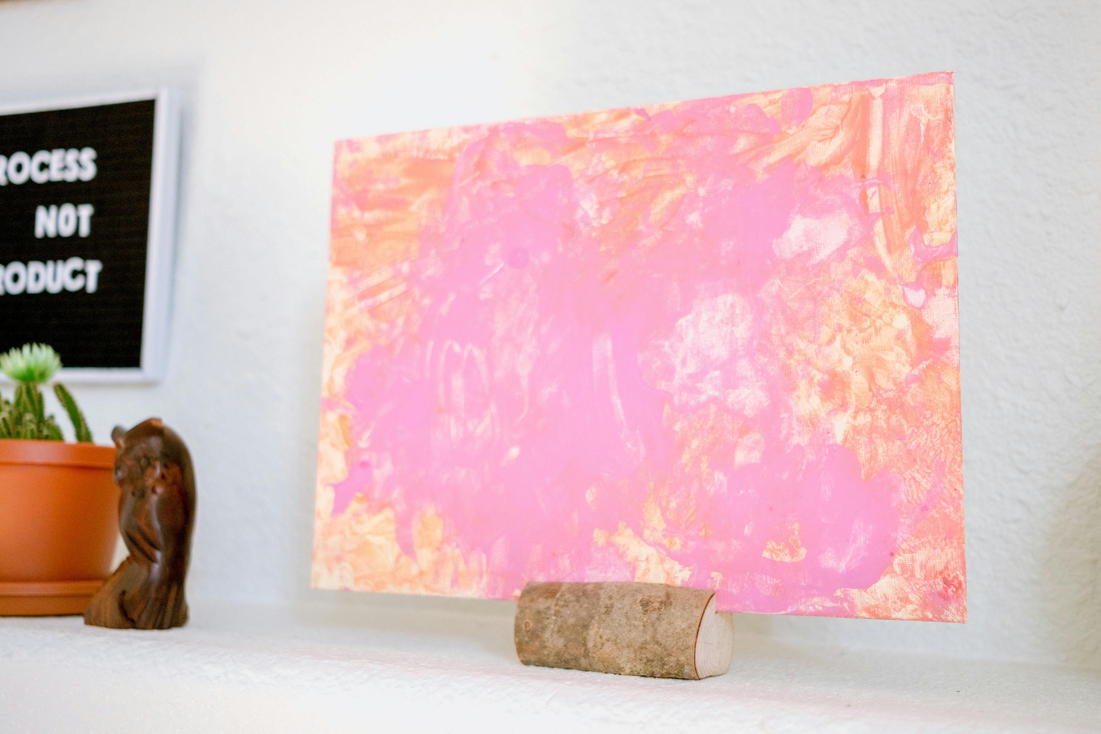 Pink and orange abstract painting on a white wall
