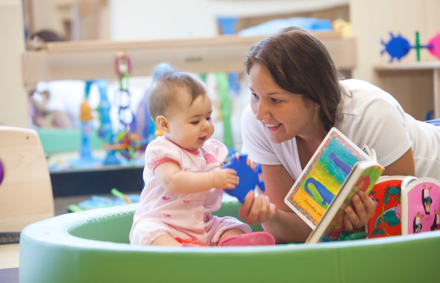 Person and child playing with a book and toy