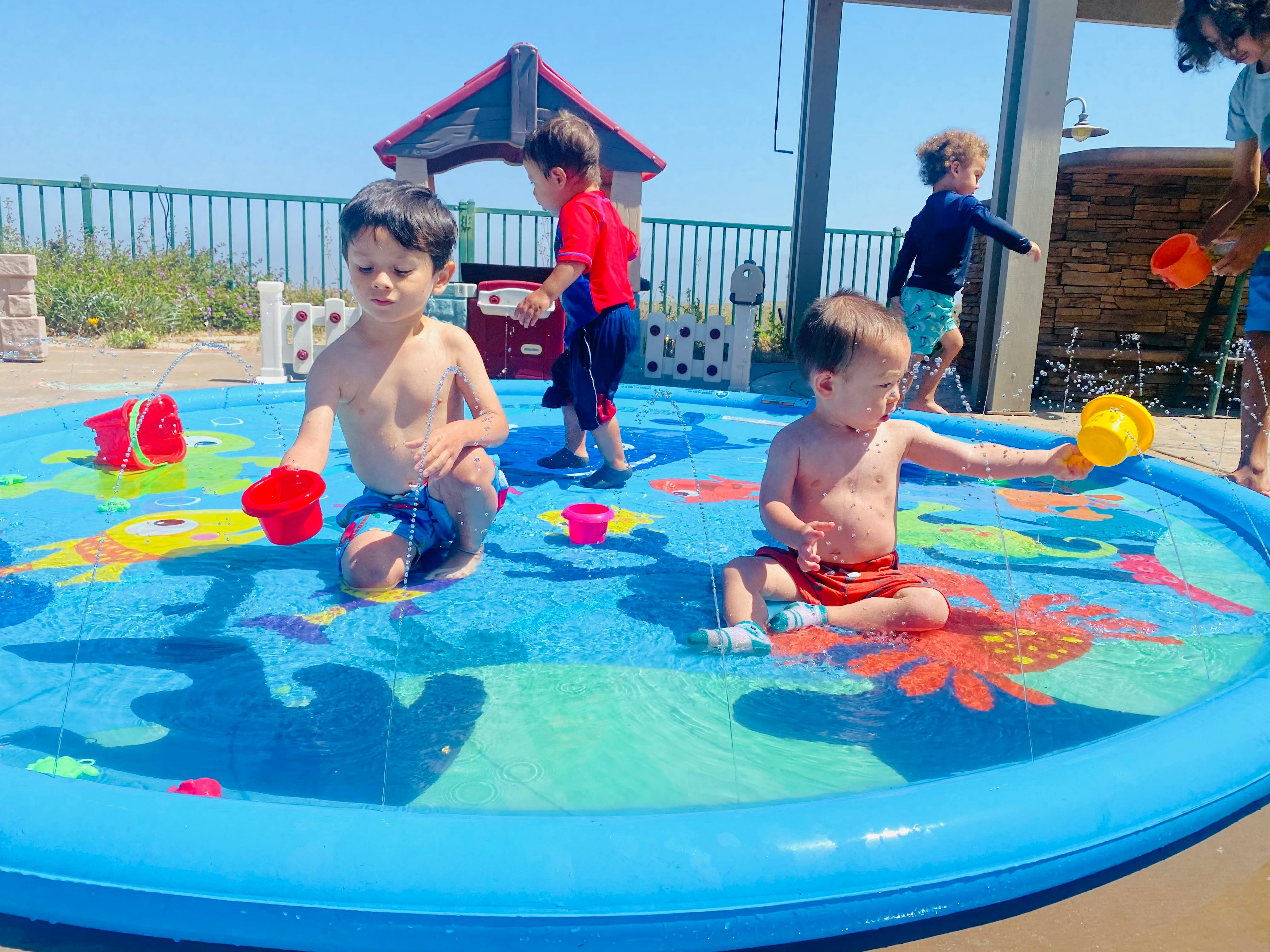 Children playing in a shallow inflatable pool