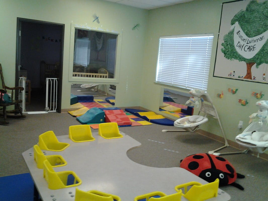 Playroom with small yellow chairs around a table and colorful play mats