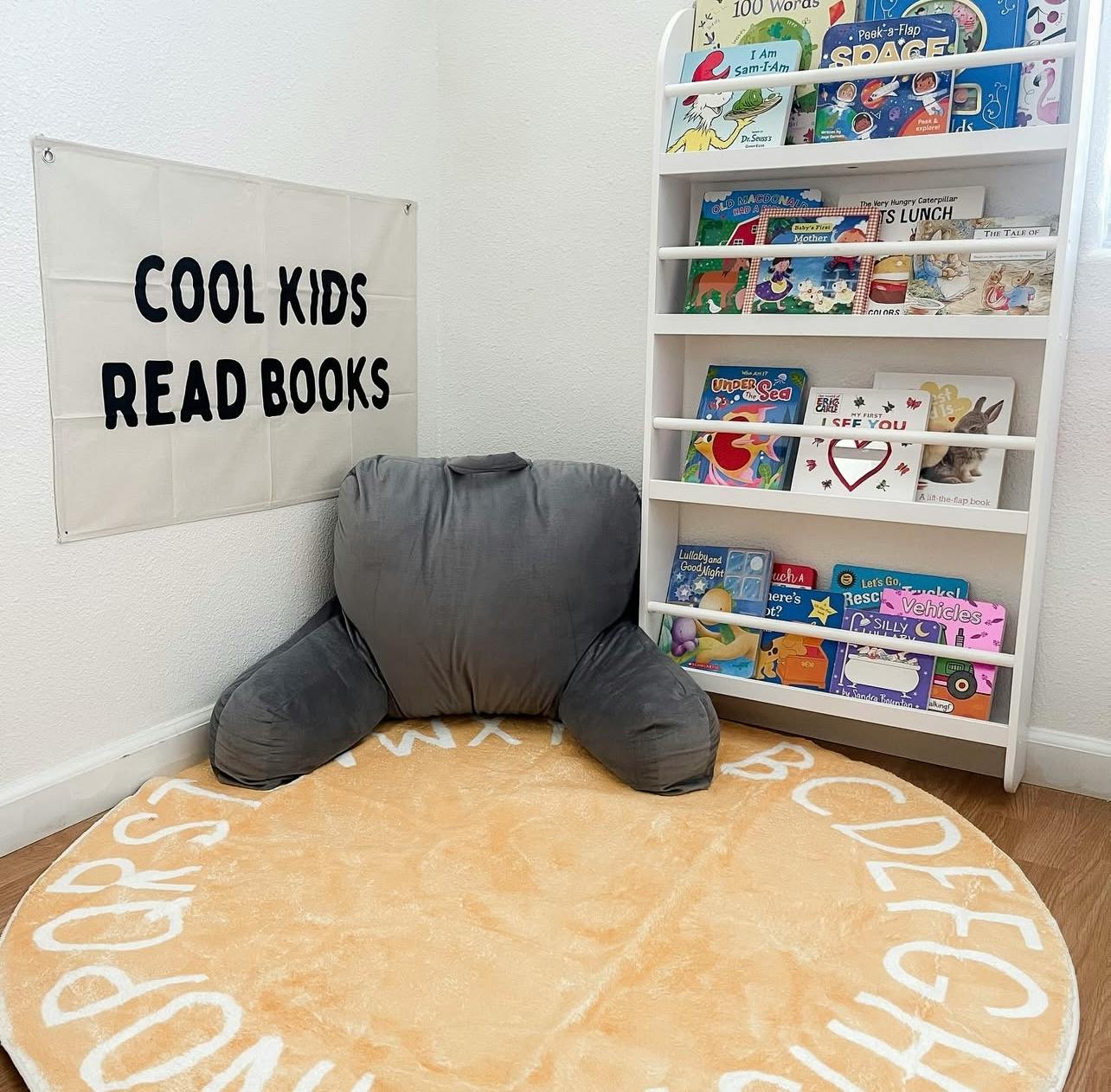 Reading nook with a book display shelf, floor cushion, and wall hanging