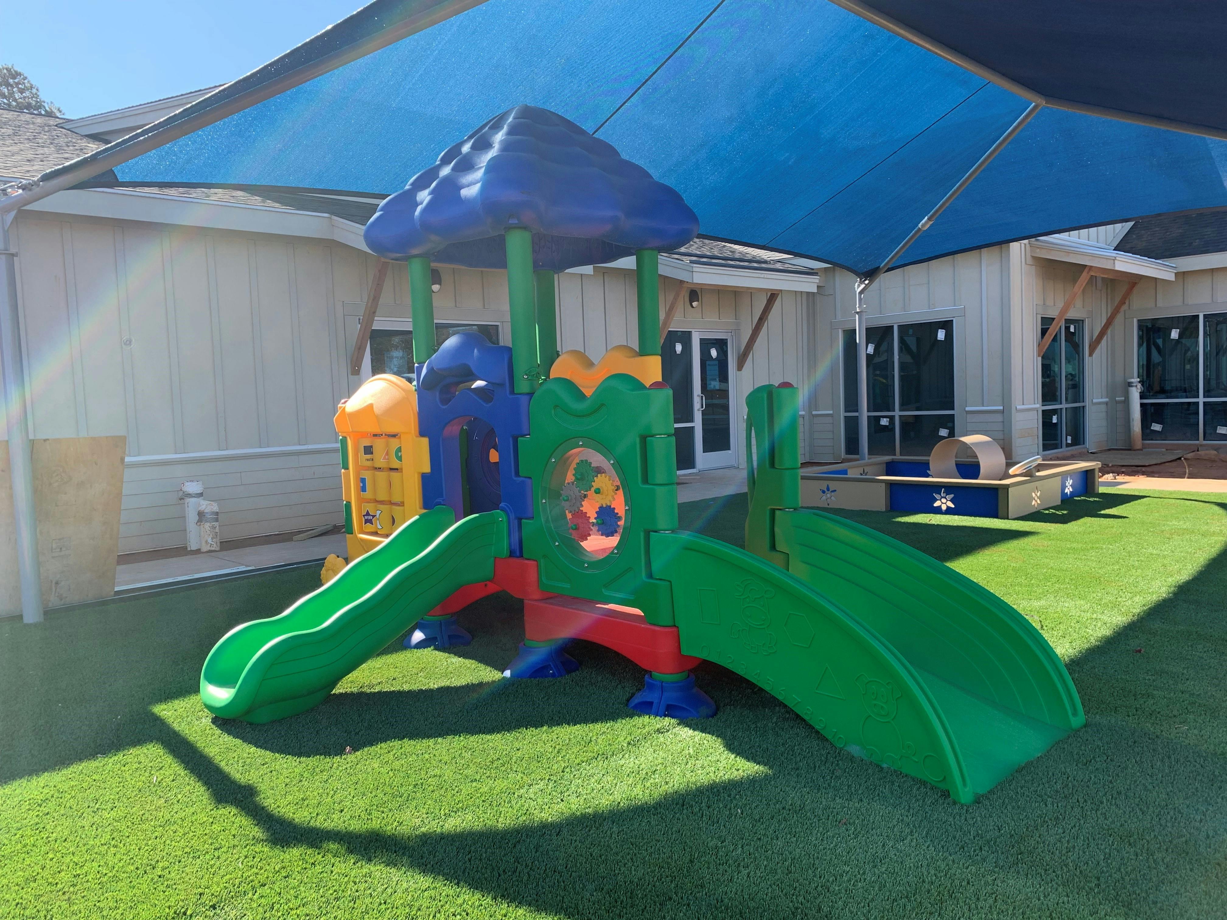 Playground with slides and climbing structure on artificial turf