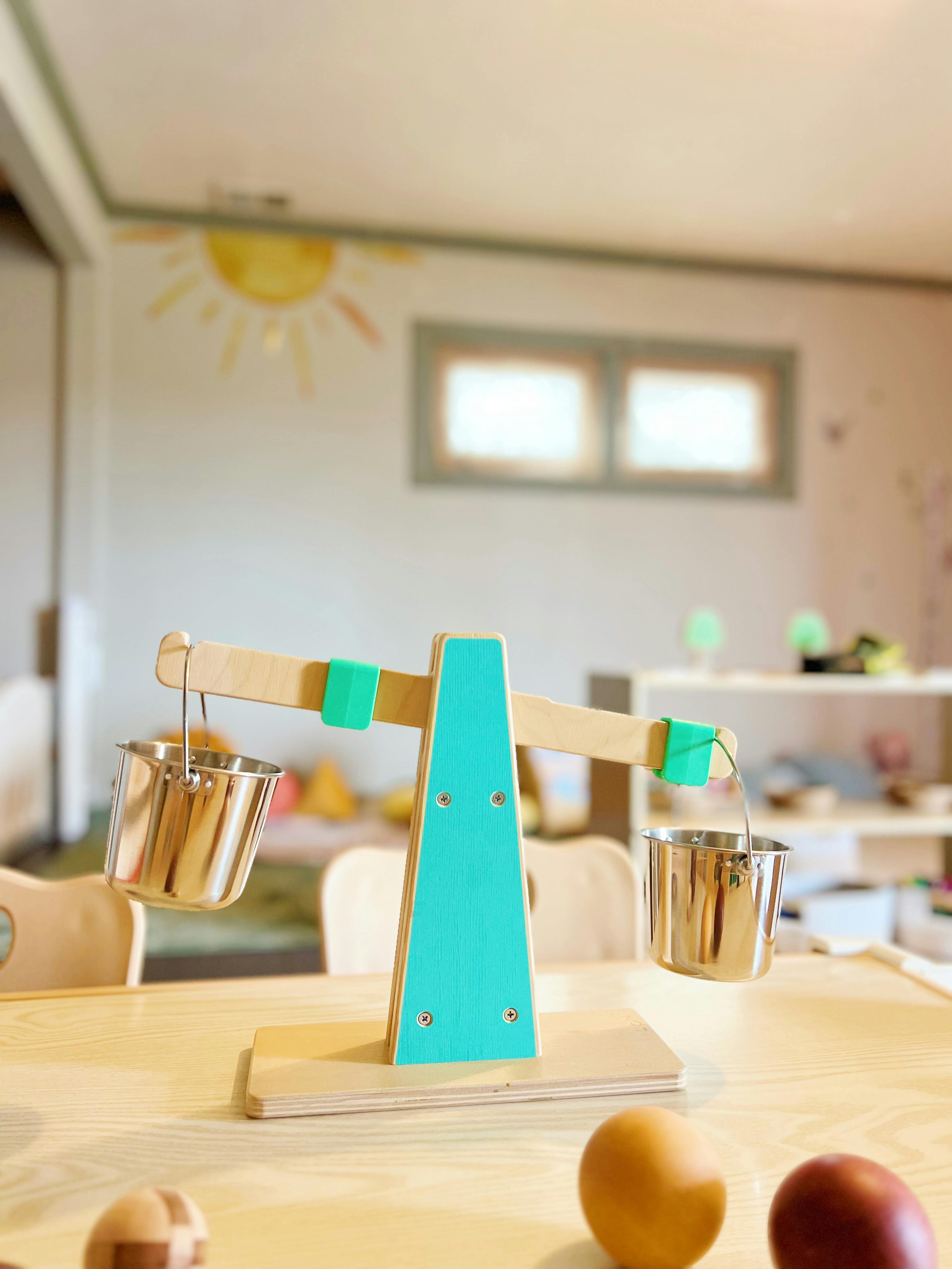 Wooden balance scale with two metal buckets on a table