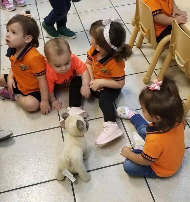 Children sitting on the floor with a stuffed animal