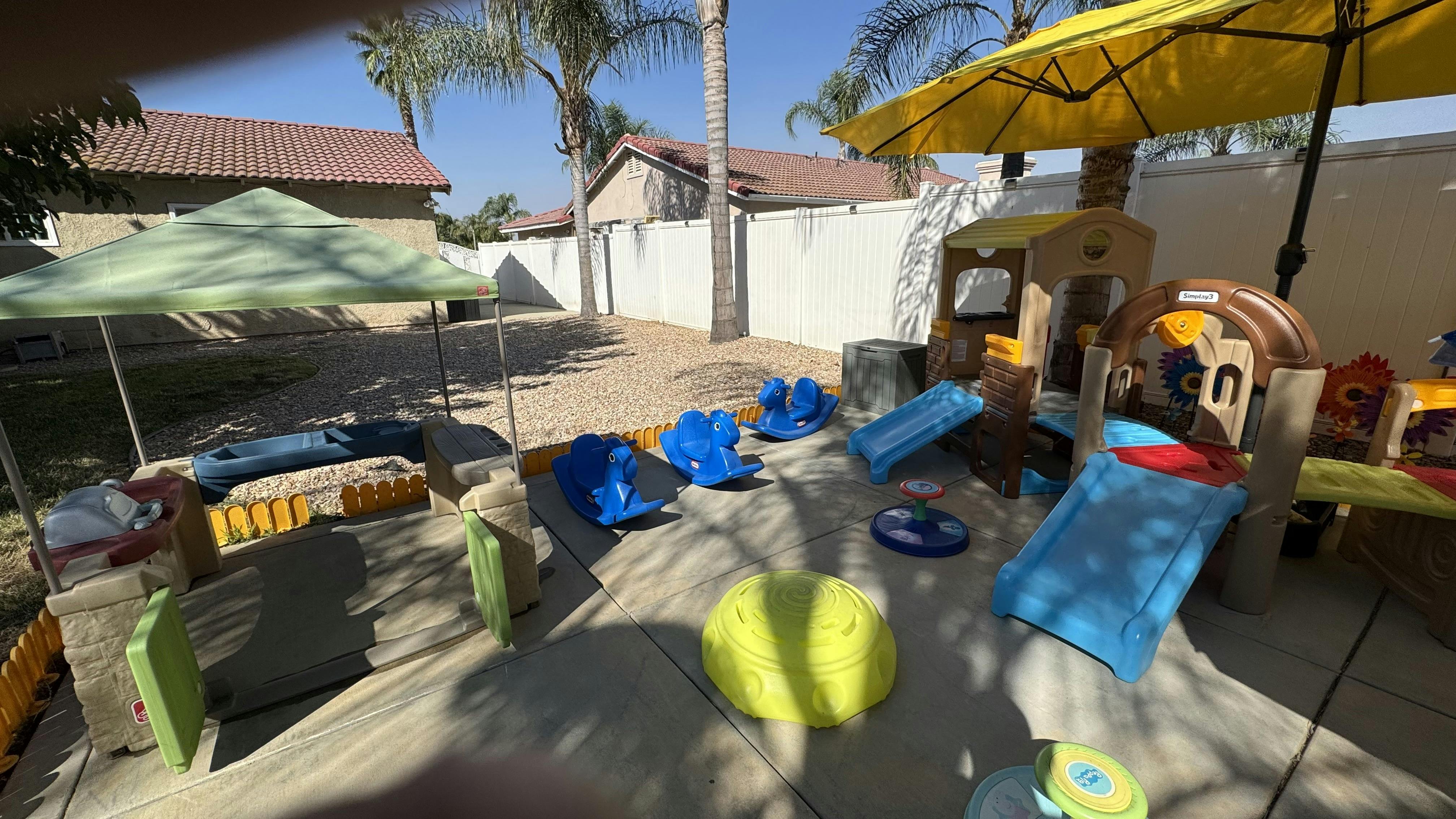 Outdoor playground with slides, playhouses, and umbrellas