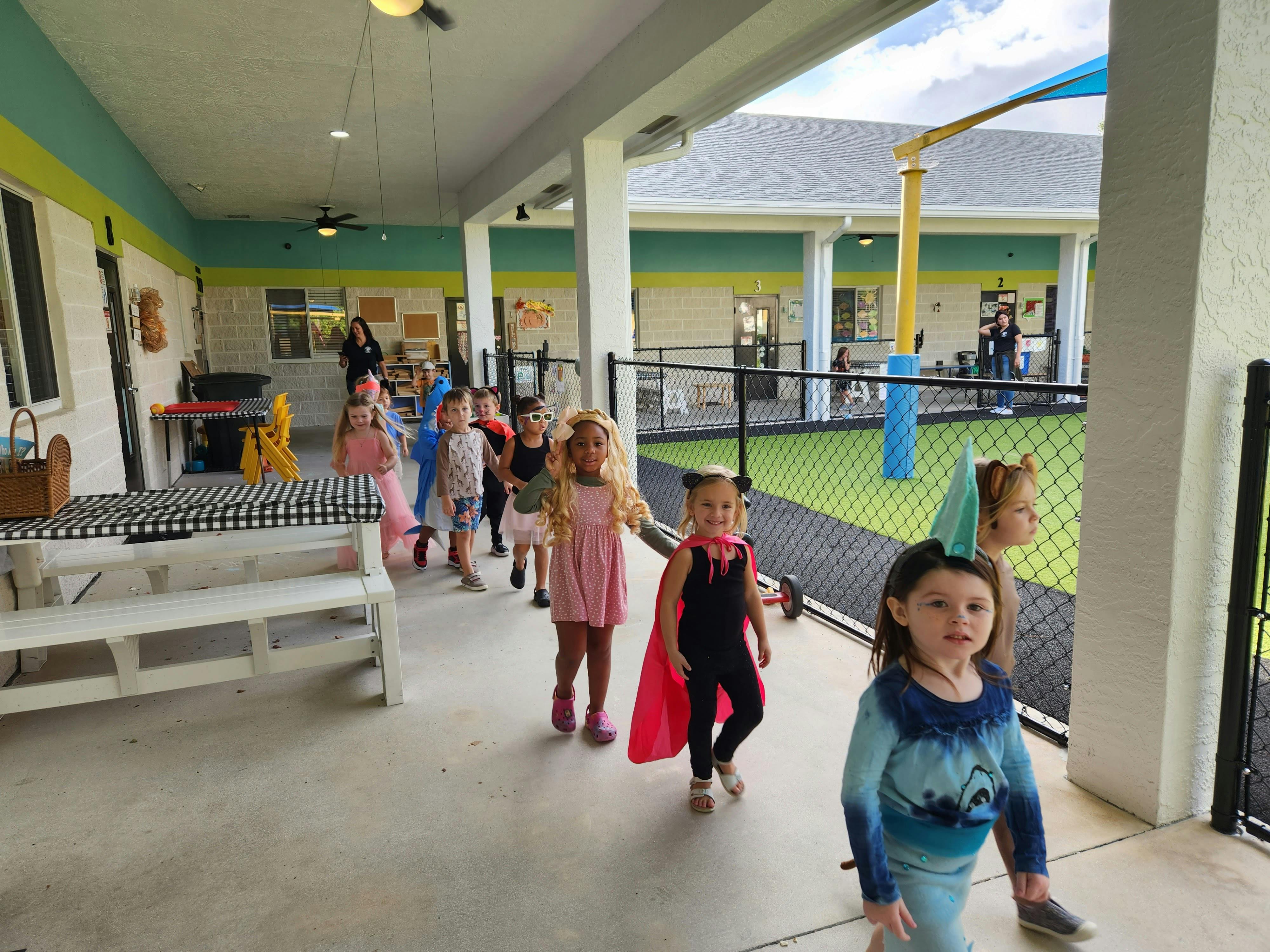Children in costumes walking on a covered walkway