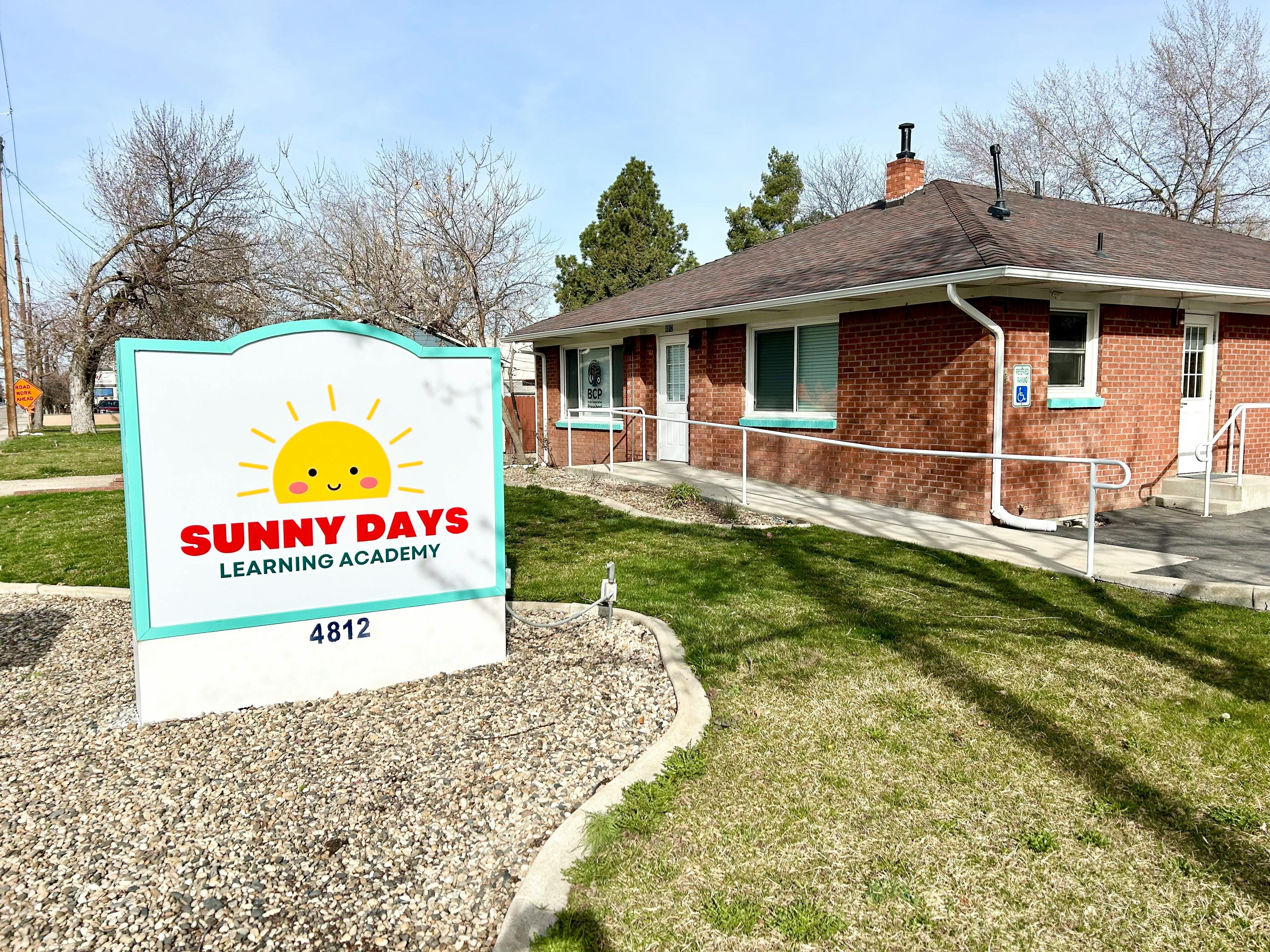 Sunny Days Learning Academy sign in front of a brick building