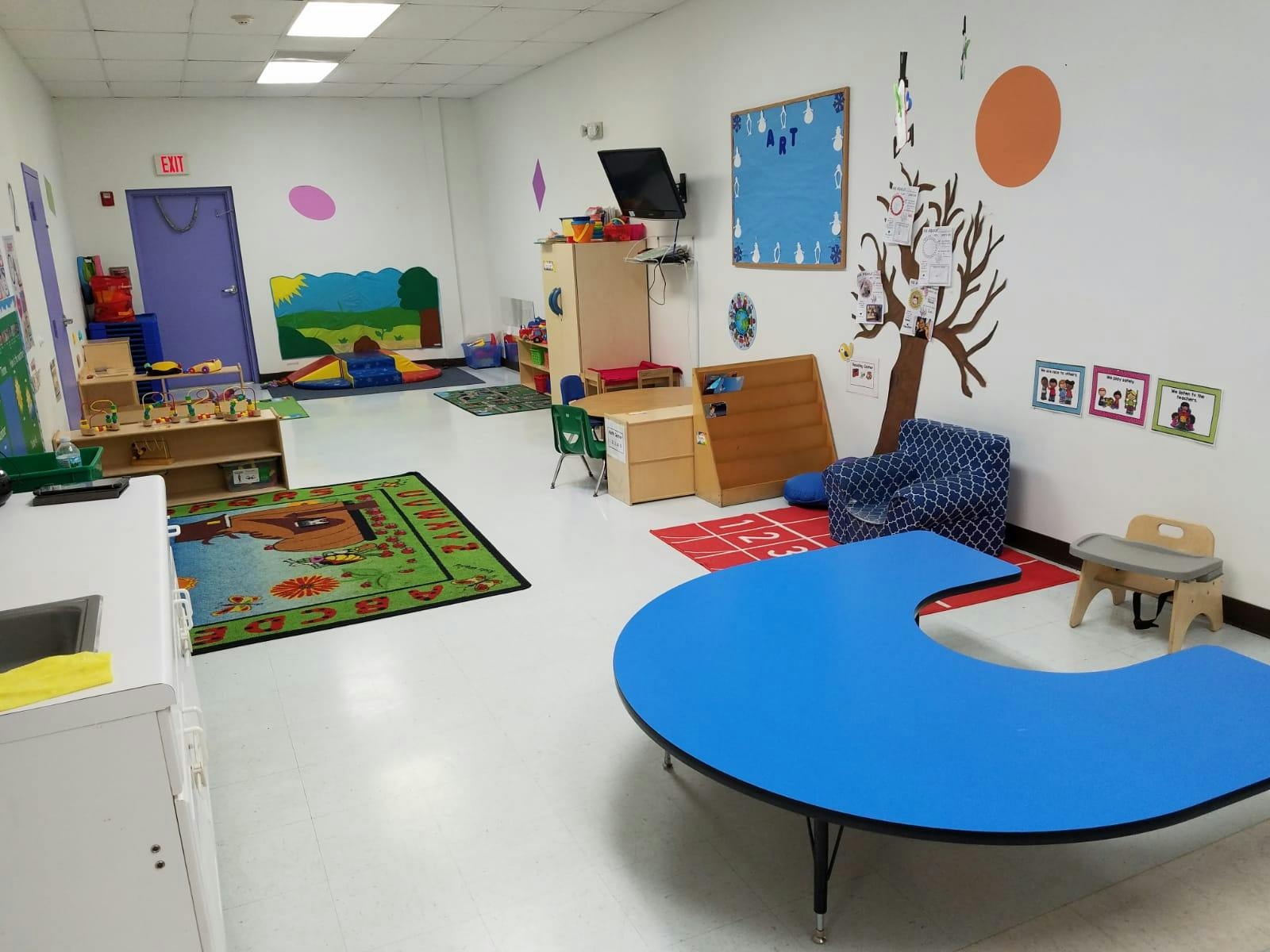 Classroom with a blue U-shaped table and various learning materials